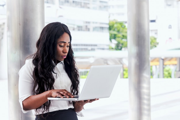 Mujer africana trabajando en la computadora portátil