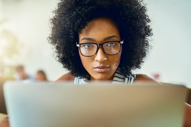 Mujer africana y trabajando con oficina de portátiles y empresa como diseñadora web en agencia digital Persona femenina orgullo y concentración en la tecnología para proyecto de asignación o breve en carrera creativa