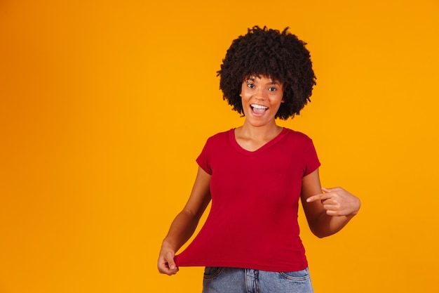 Mujer afro apuntando a la camiseta con espacio para texto.