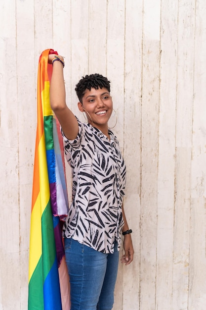 Mujer afro bailando con bandera del orgullo