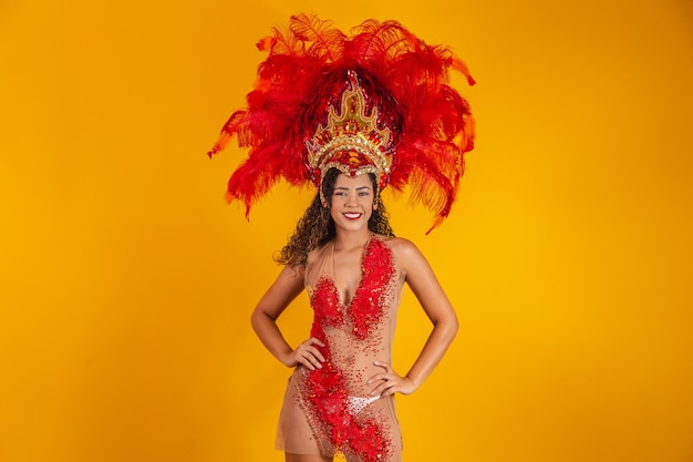 Mujer afro brasileña posando en traje de samba sobre fondo amarillo con espacio libre. Traje de samba vestido brasileño.