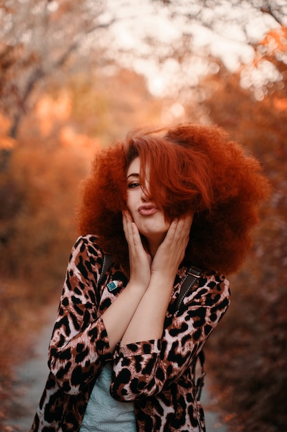 Mujer con afro camina en el parque en otoño