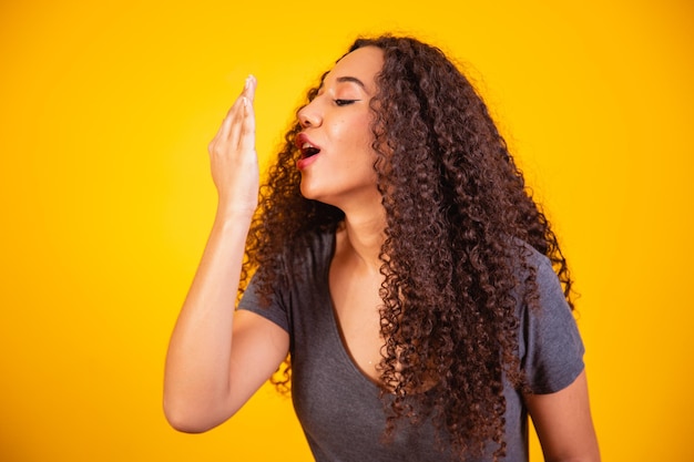 Mujer afro comprobando su respiración.