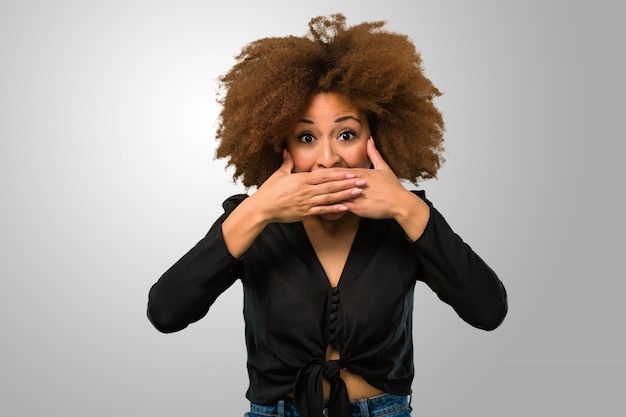 Mujer afro cubriendo su boca