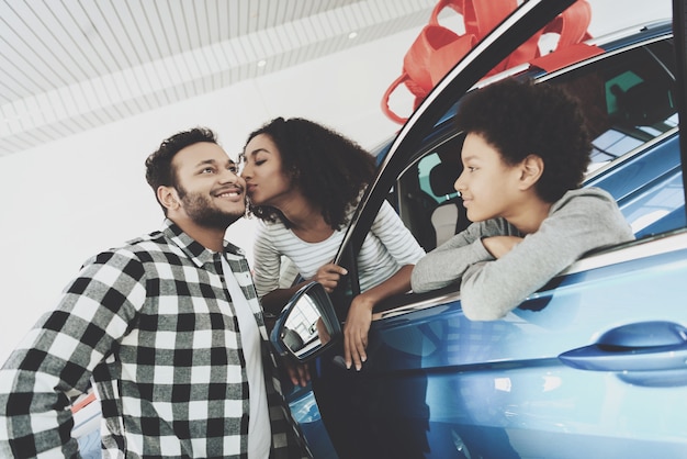 Foto una mujer afro le da un beso a su marido para un auto de regalo.