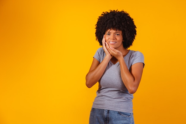 Mujer afro con dolor de muelas en amarillo