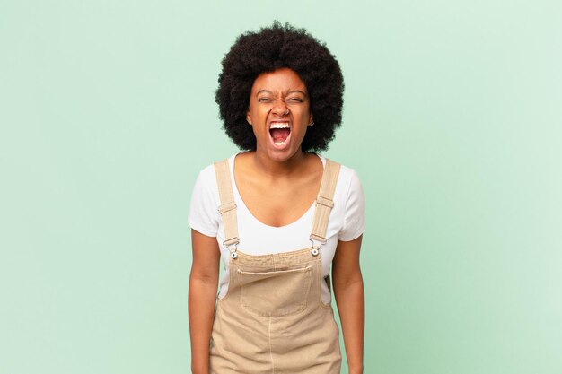 Mujer afro gritando agresivamente, luciendo muy enojada, frustrada, indignada o molesta, gritando sin concepto de chef