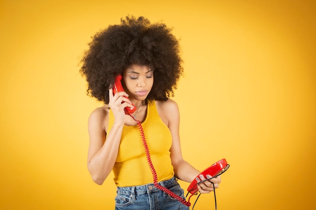 Mujer afro hablando por teléfono fijo