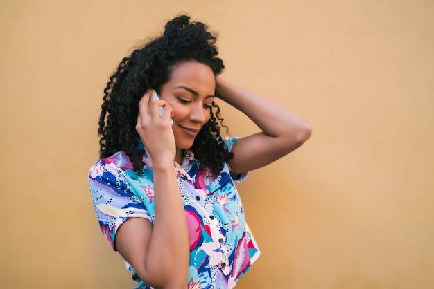 Mujer afro hablando por teléfono.