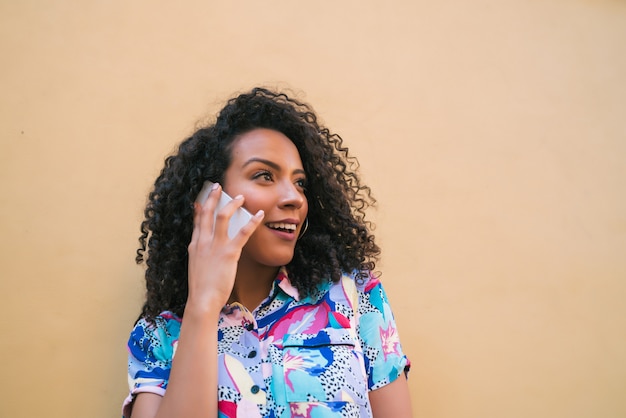 Mujer afro hablando por teléfono.