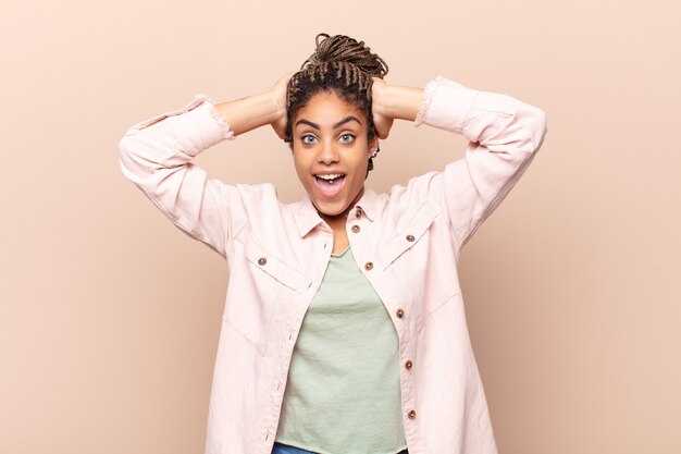 Mujer afro joven que parece feliz, despreocupada, amigable y relajada