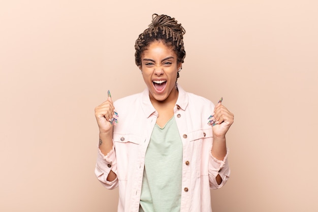 Mujer afro joven que se siente feliz, positiva y exitosa aislada