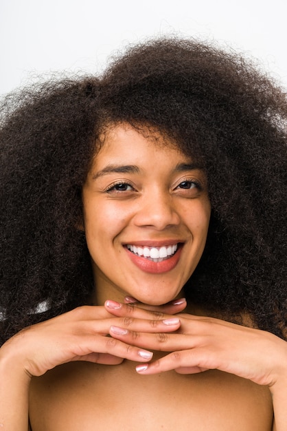 Mujer afro joven que sonríe en blanco