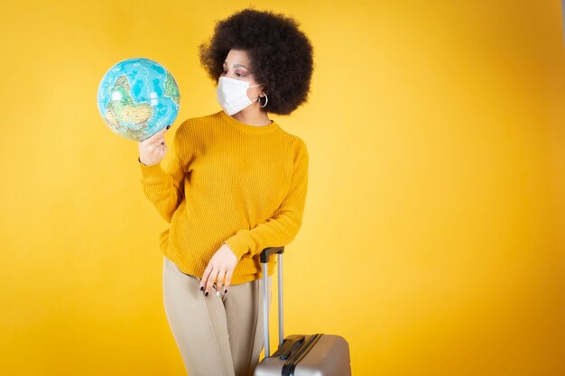 Mujer afro con maleta, antifaz, no puedo viajar y dar la vuelta al mundo