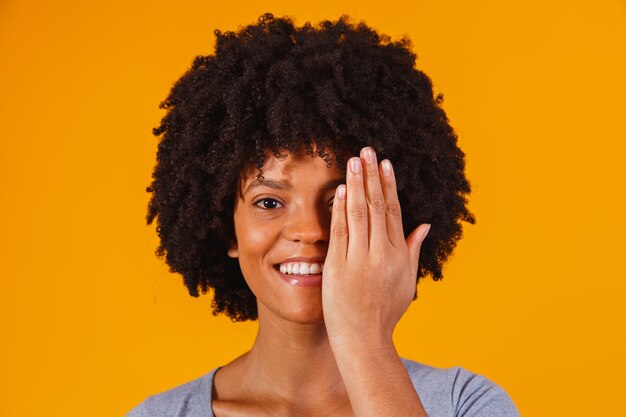 Mujer afro con la mano cubriendo la mitad de su rostro