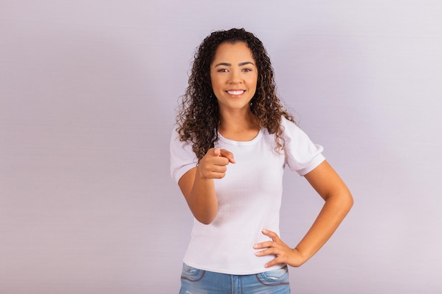 Mujer afro mirando a la cámara mientras te apunta