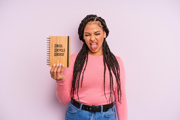 Mujer afro negra con actitud alegre y rebelde bromeando y sacando la lengua concepto de reciclaje