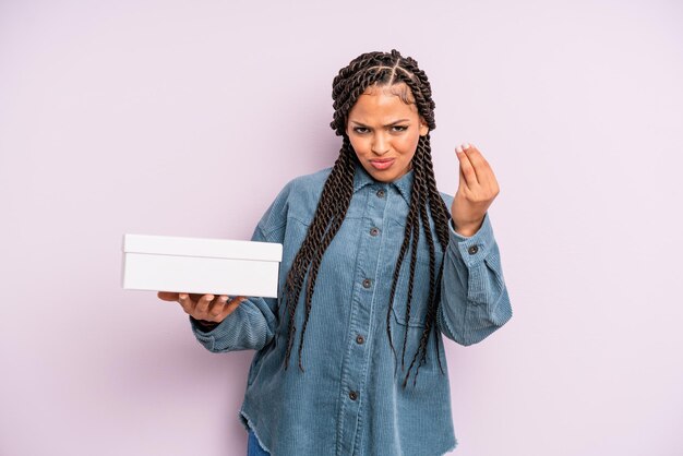 Mujer afro negra haciendo capice o gesto de dinero, diciéndole que pague. concepto de caja de paquetes