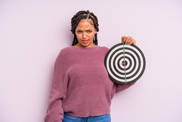 mujer afro negra que parece desconcertada y confundida. concepto de dardo objetivo