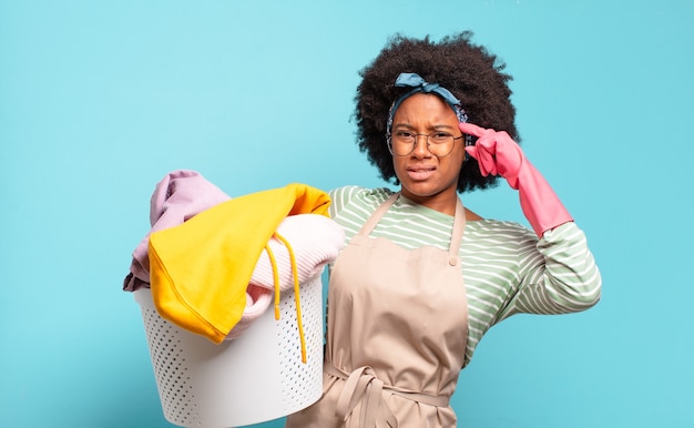 Mujer afro negra que se siente confundida y perpleja, mostrando que estás loco, loco o loco.