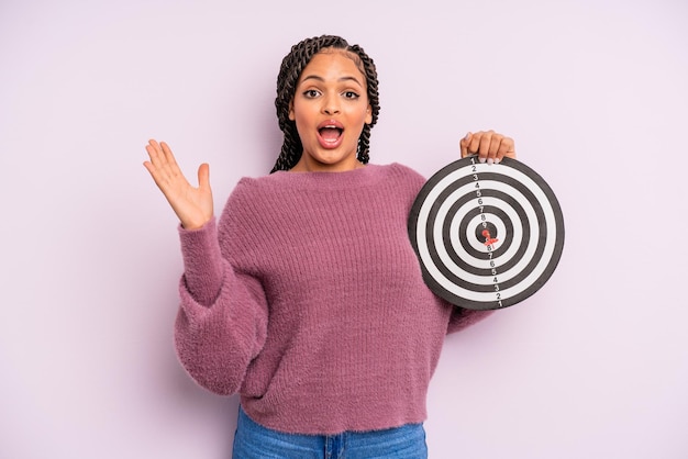 mujer afro negra que se siente feliz y asombrada por algo increíble. concepto de dardo objetivo