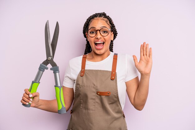 Mujer afro negra que se siente feliz y asombrada por algo increíble concepto de jardinero o agricultor