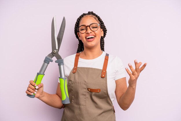 Mujer afro negra que se siente feliz sorprendida al darse cuenta de una solución o idea del concepto de jardinero o agricultor