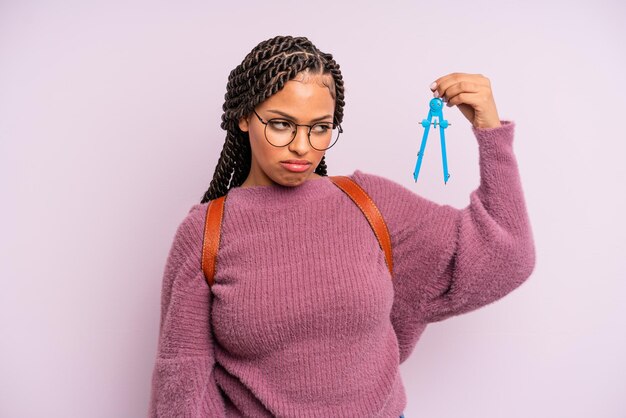 Mujer afro negra que se siente triste, molesta o enojada y mira hacia un lado. medir el concepto de estudiante de brújula