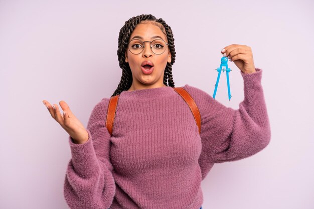 mujer afro negra sorprendida, conmocionada y asombrada con una sorpresa increíble. medir el concepto de estudiante de brújula