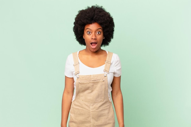 Mujer afro que parece muy conmocionada o sorprendida, mirando con la boca abierta diciendo concepto de chef wow