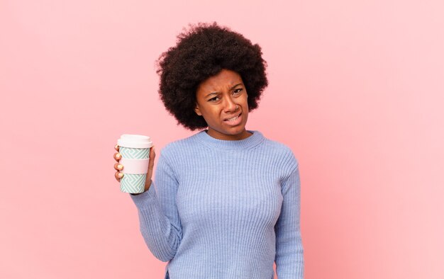 Mujer afro que se siente perpleja y confundida, con una expresión muda y atónita mirando algo inesperado. concepto de cafe