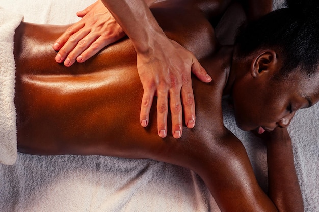 Mujer afro recibiendo terapia manual médica profesional