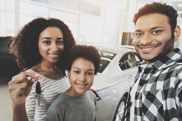 Mujer afro rizada tiene llaves compra de coche familiar.