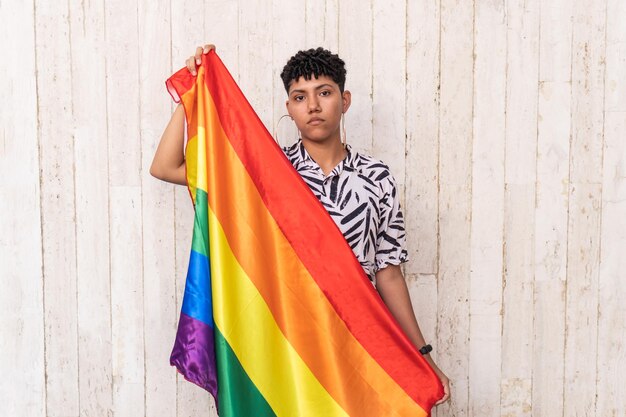 Mujer afro sosteniendo una bandera del orgullo gay en apoyo del Orgullo Gay en la calle