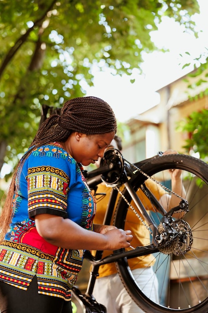 Foto mujer afroamericana arreglando una bicicleta