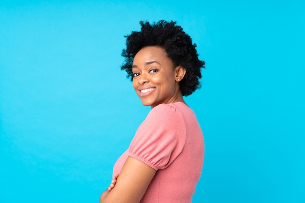 Mujer afroamericana en azul aislado riendo