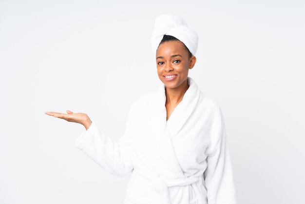 Mujer afroamericana con bata de baño sobre pared blanca