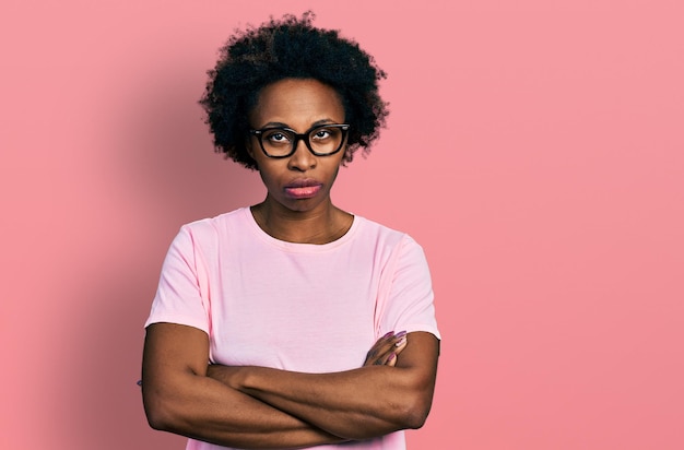 Mujer afroamericana con cabello afro con ropa casual y anteojos expresión de desaprobación escéptica y nerviosa en la cara con brazos cruzados persona negativa