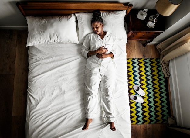 Mujer afroamericana en cama durmiendo solo