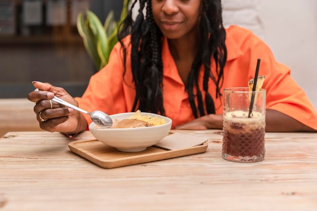 Mujer afroamericana comiendo saludable acai bowlOrgánico crudivegano saludable