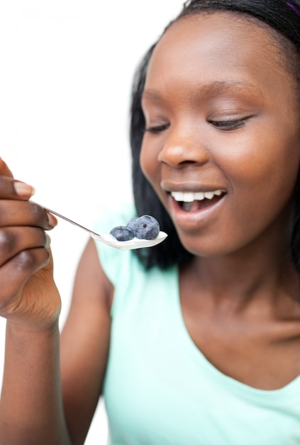 Mujer afroamericana comiendo un yogurt con arándanos