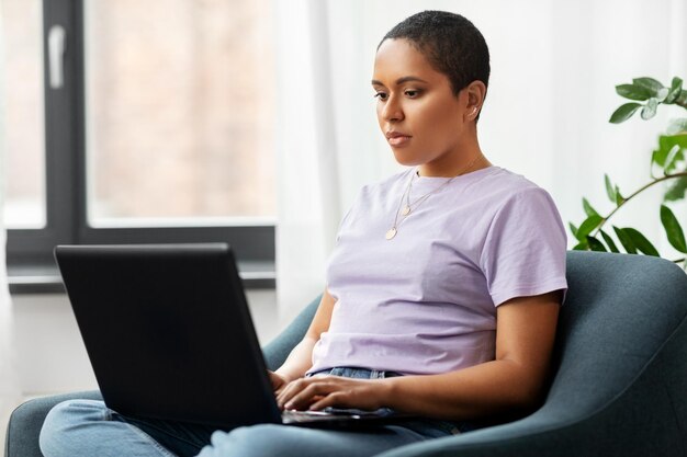 mujer afroamericana con una computadora portátil en casa
