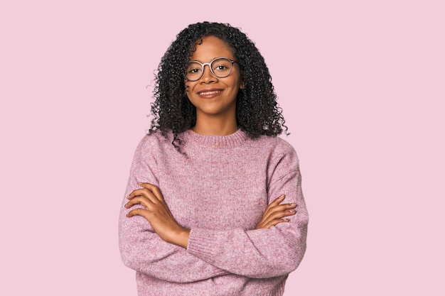 Mujer afroamericana en un entorno de estudio que se siente segura cruzando los brazos con determinación