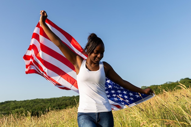 Mujer afroamericana envuelta en bandera americana