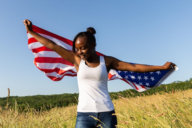 Mujer afroamericana envuelta en bandera americana