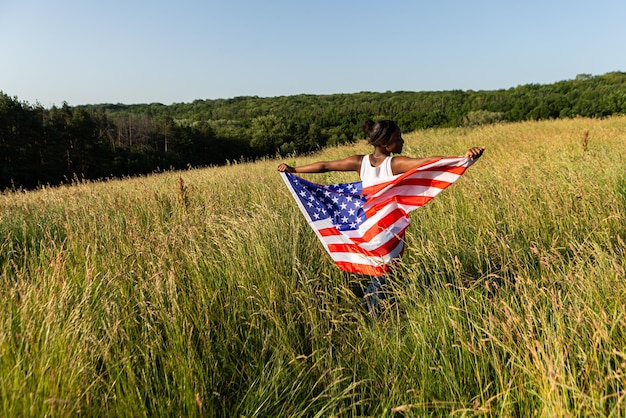 Mujer afroamericana envuelta en bandera americana