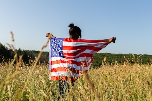 Mujer afroamericana envuelta en bandera americana