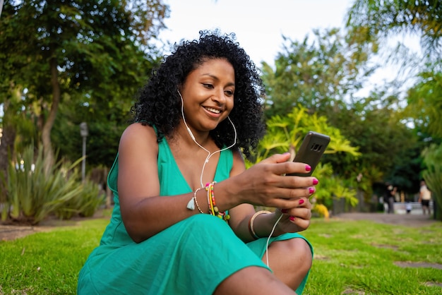 Mujer afroamericana escuchando música en el parque