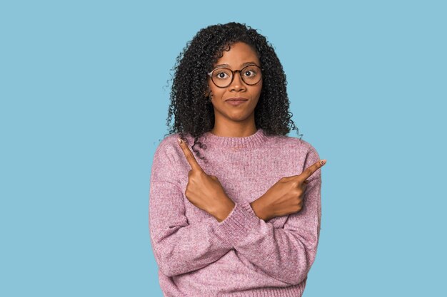 Foto una mujer afroamericana en el estudio estableciendo puntos lateralmente está tratando de elegir entre dos opciones