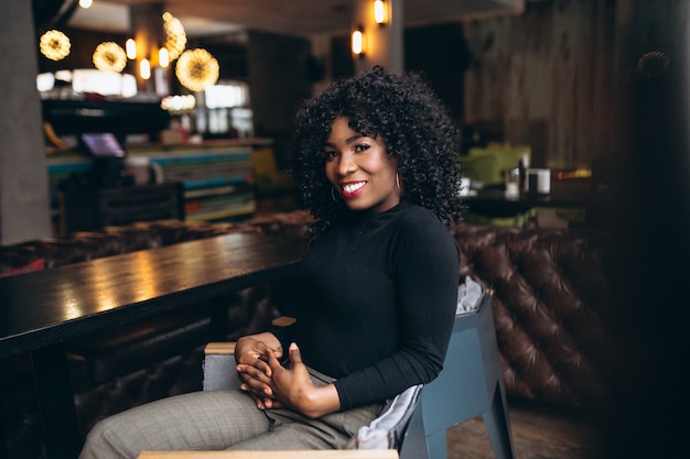 Mujer afroamericana feliz en un café